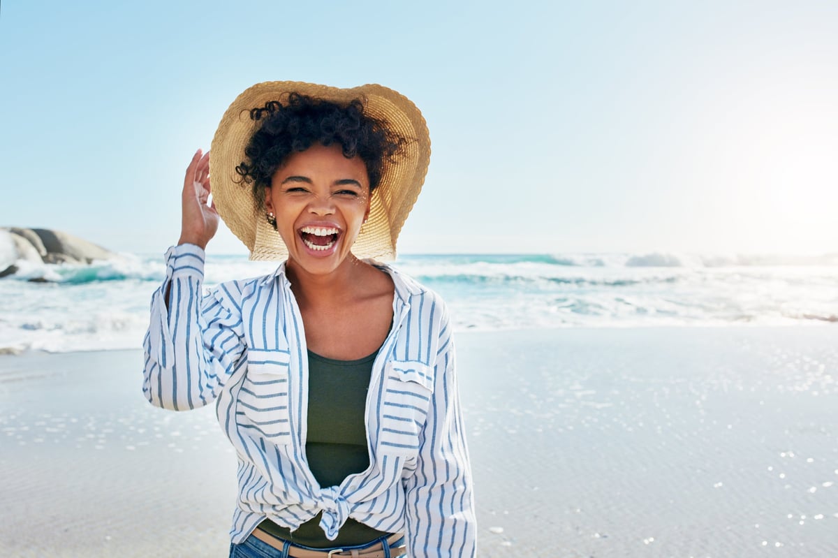 Shot of a young woman enjoying a day at the beach