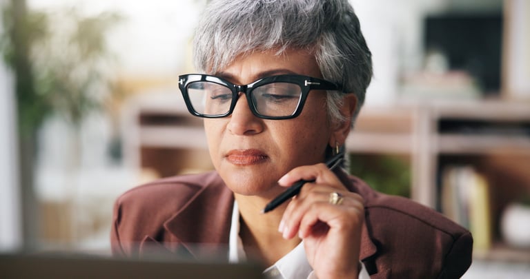 Mature woman looking thoughtful and focused while working toward a decision